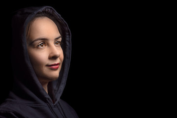 Portrait pensive artist painter girl in black hood posing in a studio. Creative painter girl, isolated on black