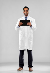 medicine, science and profession concept - smiling indian male doctor or scientist in white coat with tablet computer over grey background