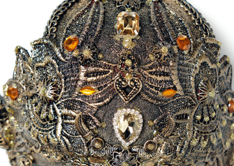 Closeup studio shot of creative metal mask with jewels and feathers isolated on white background