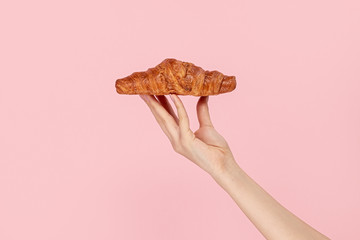 Woman presenting delicious pastry on pink background 