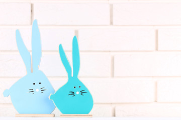 Easter wooden rabbits on brick wall background