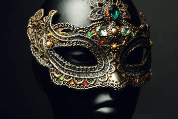 Black head of mannequin in creative metal mask with jewels