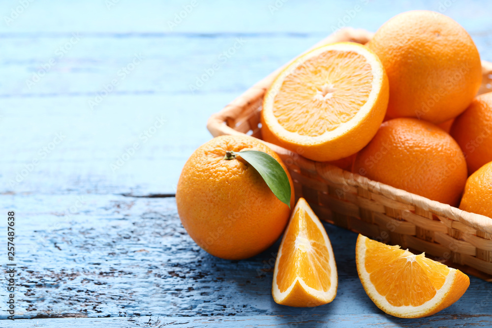 Sticker orange fruit with green leaf and basket on blue wooden table