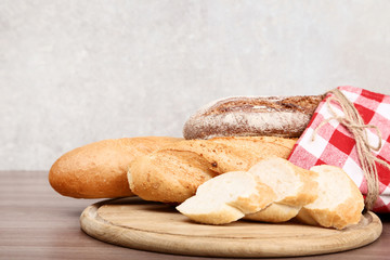 Fresh baguettes with red napkin on wooden table