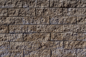 Background of brown-grey stone bricks displayed horizontally in a wall 