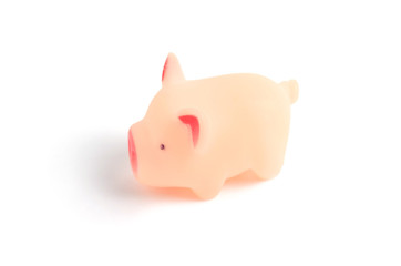 Small rubber, pink pig, toy on white background closeup.