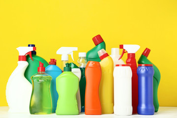 Bottles with detergent on yellow background