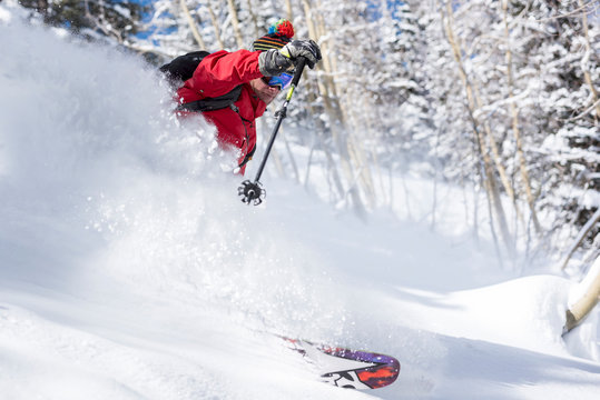 Man Skiing Downhill Into Deep Powder Snow On Snowy Landscape