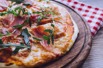 Italian pizza with prosciutto and arugula