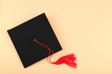 Graduation cap on beige background