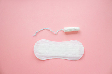 women intimate hygiene products - sanitary pads and tampon on pink background.