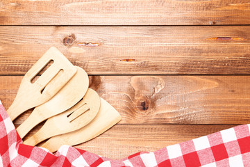 Wooden cutlery with red napkin on brown table