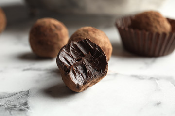 Tasty raw chocolate truffles on marble table, closeup