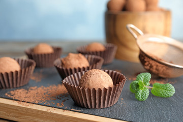 Tasty chocolate truffles on board, closeup view