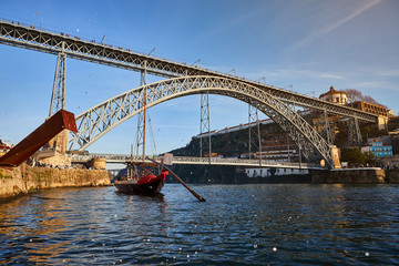 Naklejka premium View of the historic city of Porto, Portugal with the Dom Luiz bridge. A metro train can be seen on the bridge