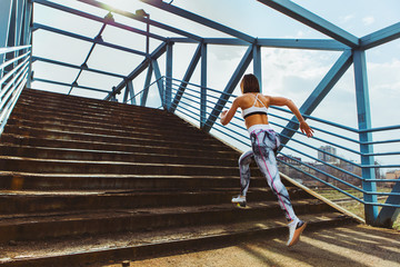 Obraz na płótnie Canvas Sporty woman is running in urban environment