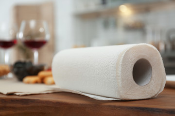 Roll of paper towels on table in kitchen, space for text