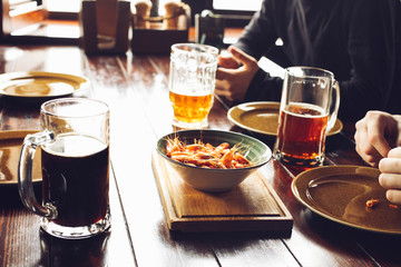 friends drinking beer from mugs in brewery pub