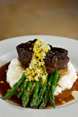 Filet on a bed of asparagus and mashed potatoes with gravy