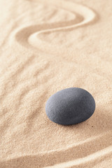 Zen stone Japanese sand garden round rock in sand. Buddhism or yoga background for spiritual purity and concentration.