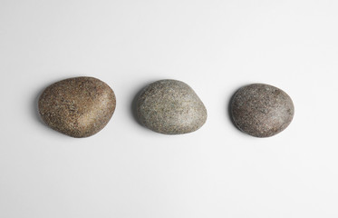Fototapeta na wymiar Zen stones on white background, top view