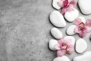 Türaufkleber Badezimmer Zen-Steine und exotische Blumen auf grauem Hintergrund, Draufsicht mit Platz für Text