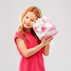 birthday and people concept - lovely red haired girl with gift box over grey background