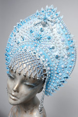 Head of woman mannequin in blue decorated Russian kokoshnick, grey studio background