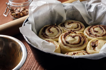 Cinnamon rolls. Freshly baked cinnamon buns with spices and cocoa filling on parchment paper. Top view. Sweet Homemade Pastry christmas baking. Close-up. Kanelbule - swedish dessert.