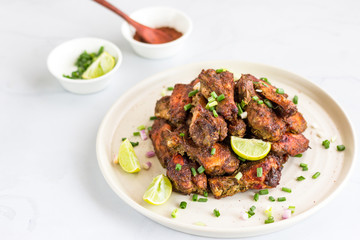 Jamaican Jerk Chicken Wings ona Plate Horizontal Photo. Caribbean Style Dry Rubbed Chicken Wings on White Background, Popular Chicken Appetizer.