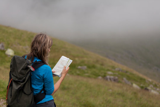 Female hiker consults map for direction