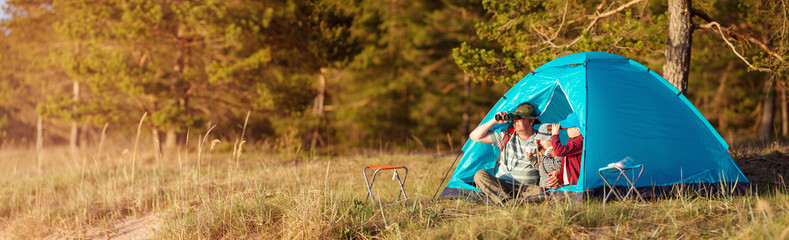 Family resting with tent in nature at sunset