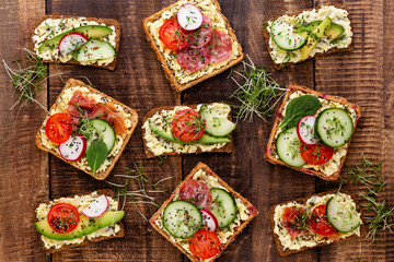 Sandwiches with cream cheese, vegetables and salami.