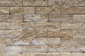 Background of yellow stone bricks displayed horizontally in a wall 