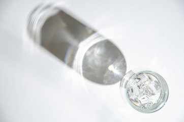 Water in a glass cup and shade on the table.  Top view.