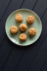 Homemade healthy sugar free sweets. Muffins with dried fruits in green plate on dark background minimalist style top view