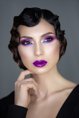 portrait of a romantic mysterious girl with a marcel wave hairstyle and bright rich makeup of the...