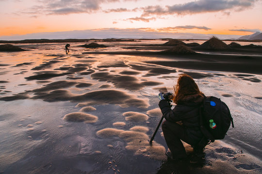 Photographer taking picture at sunset, Iceland