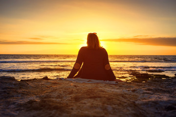 girl looks at the Sunset on Atlantic Ocean in Tenerife Canary Island Spain