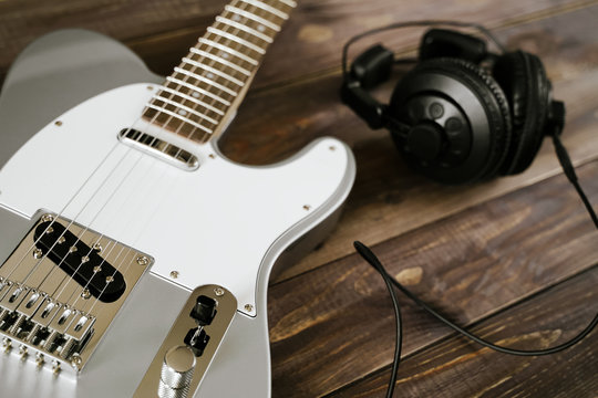Guitar electric rock background. Headphones on wooden table