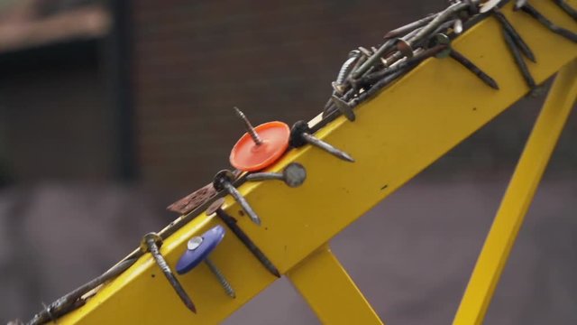 Magnetic nail collector with sharp tacks and debris at construction site