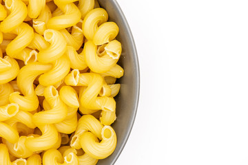 Closeup lot of whole pasta cavatappi in a grey ceramic bowl flatlay isolated on white background