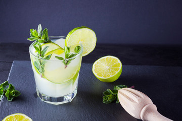 Cocktail mojito and mint on black boards. Refreshing cocktail with lime and fresh mint on slate...