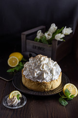 Lemon cake with white meringue on a wooden table