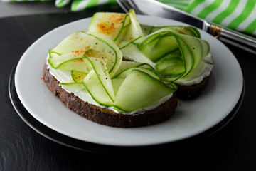 Cucumber sandwich. Healthy snack. Sandwich with cream cheese, cucumber, served on a plate. Symbolic image. Concept for a tasty and healthy meal. Close up.