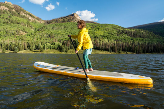 A girl stand up  paddleboarding on Lake near Creede, Colorado.