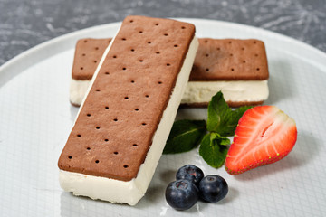 vanilla ice cream with cookies on a white plate with berries
