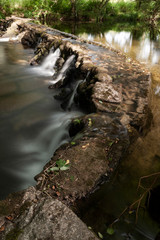 &Aacute;gua cristalina que, flui por entre as pedras de uma pequena represa construida pelo Homem, formando pequenas cascatas.