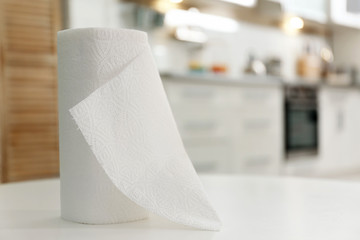 Roll of paper towels on table in kitchen, space for text