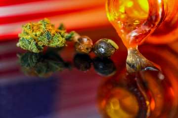 Medical Seeds and Oil  Cannanis - Germinating Seeds with Oil Cannabis CBD THC on the mirroring black background with American Flag, macro view.